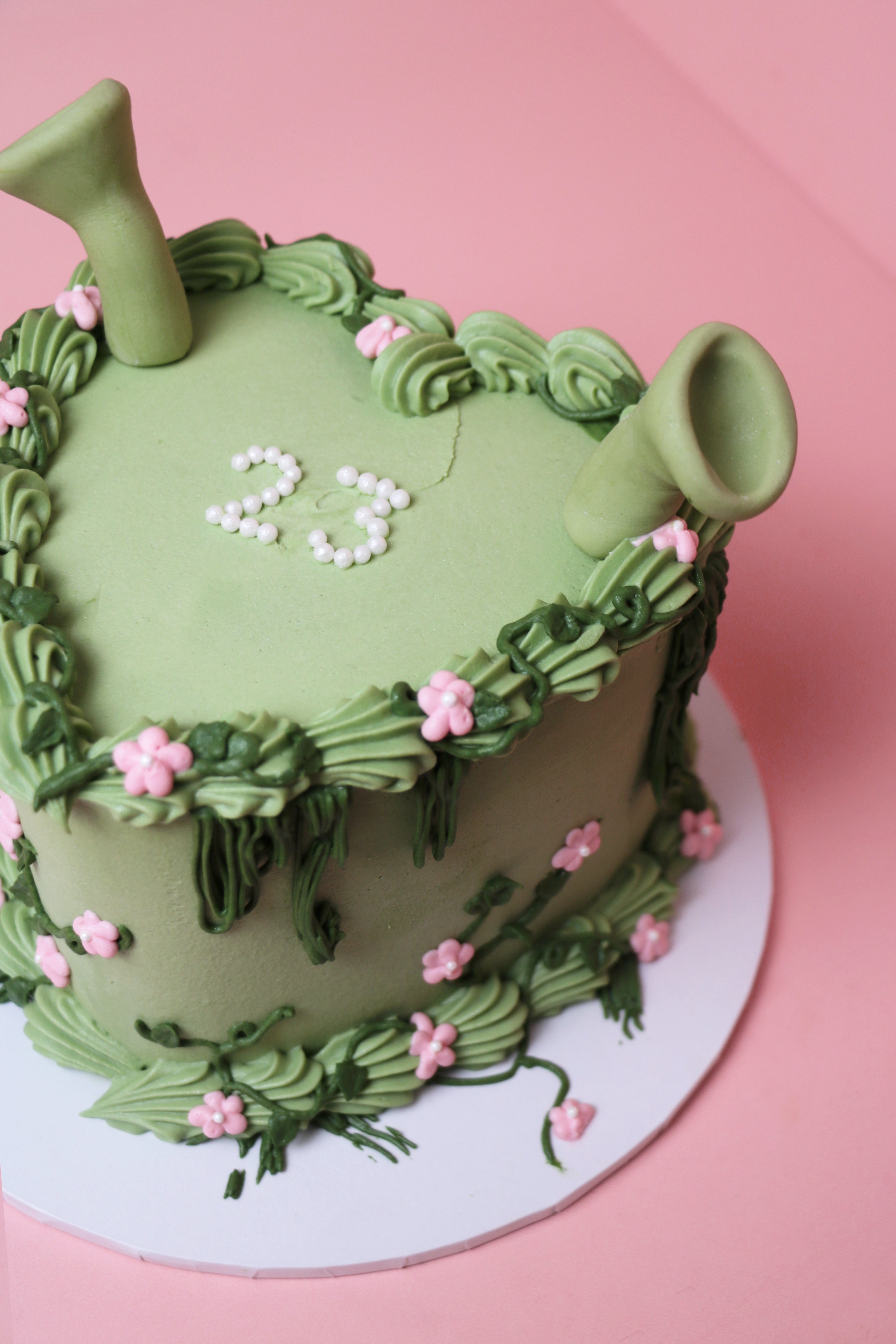 Shrek-themed green floral celebration cake with fondant ears and pink buttercream flowers handmade by Cakeasion in Uxbridge.
