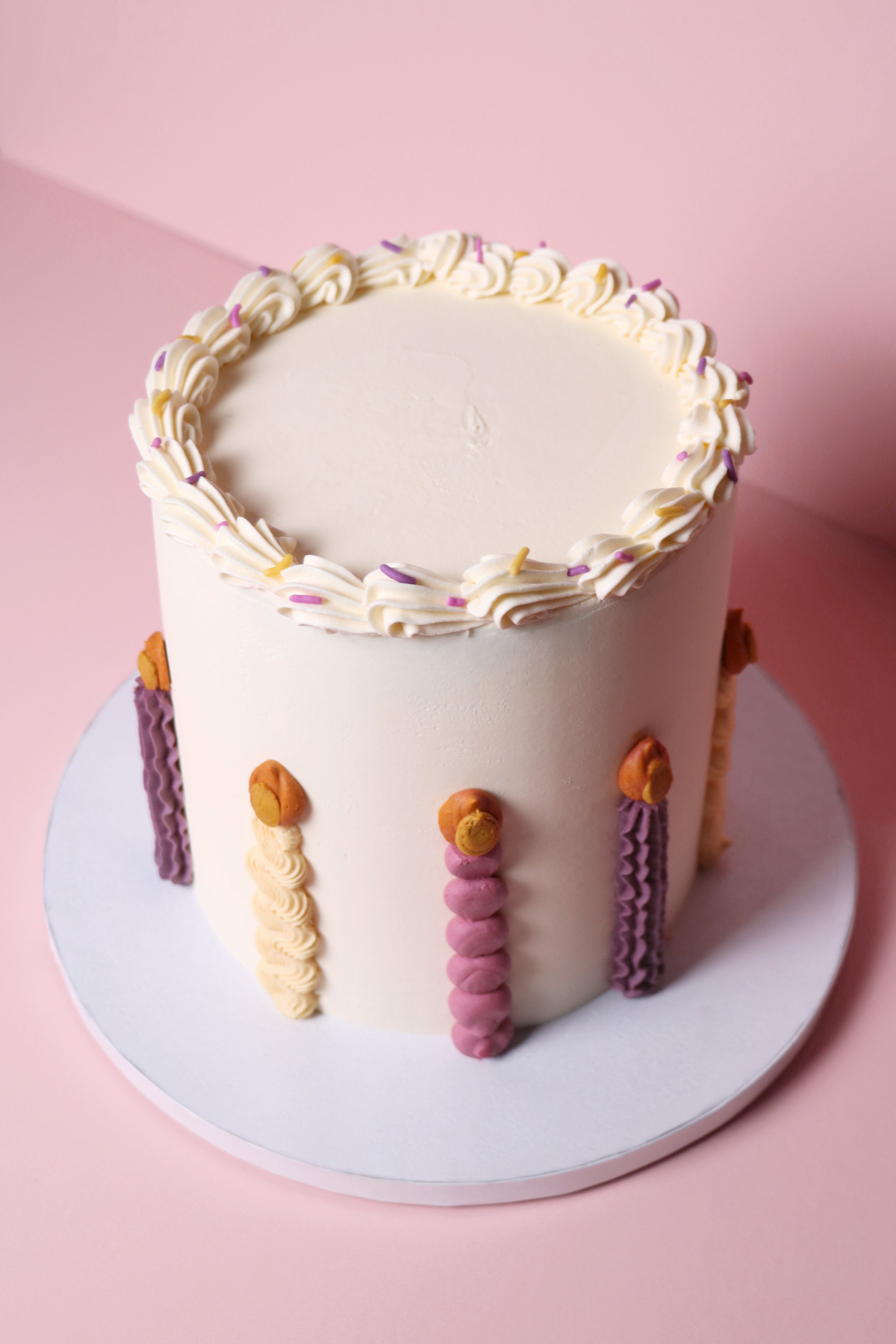 Playful birthday cake with piped buttercream candles, pastel sprinkles, and smooth vanilla finish – handmade in Uxbridge by Cakeasion.