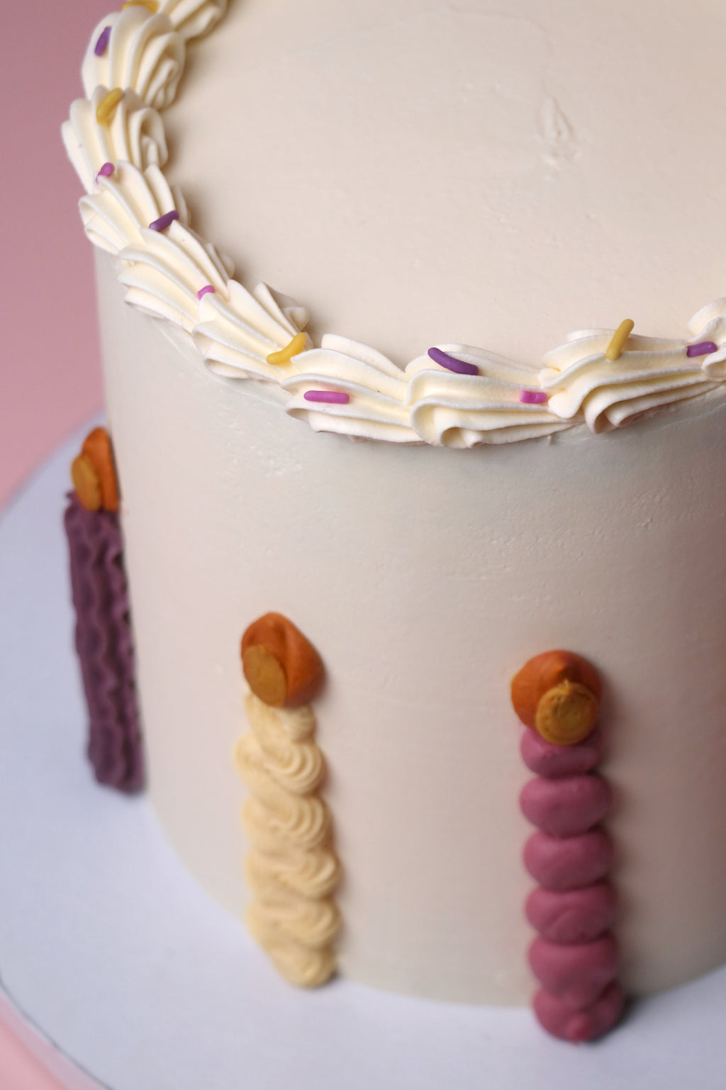 Playful birthday cake with piped buttercream candles, pastel sprinkles, and smooth vanilla finish - handmade in Uxbridge by Cakeasion.