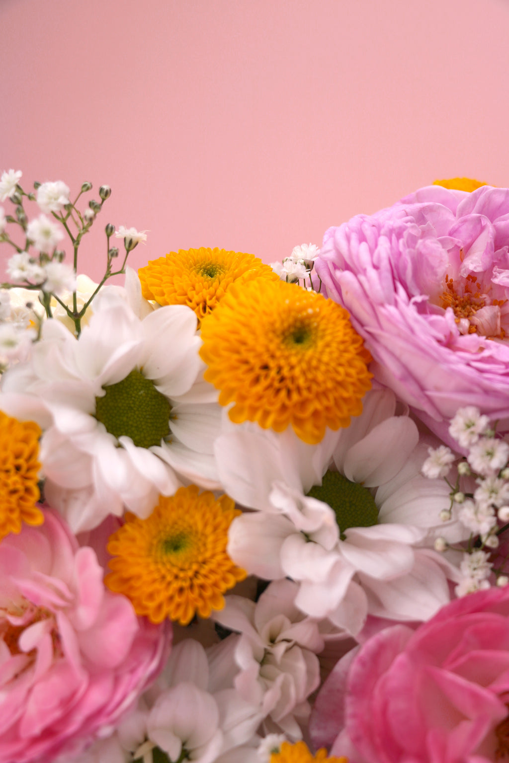 Colorful bouquet of flowers including white, orange, and pink flowers on a cake handmade by Cakeasion in Uxbridge.