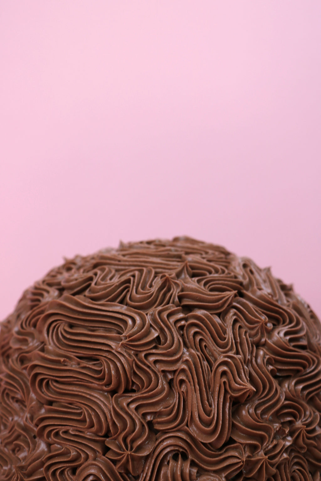 Top of a mint chocolate dome cake with piped chocolate buttercream design, Swirl piped chocolate dome cake with mint buttercream filling, Dome-shaped chocolate cake with rich buttercream texture made by Cakeasion in Uxbridge.