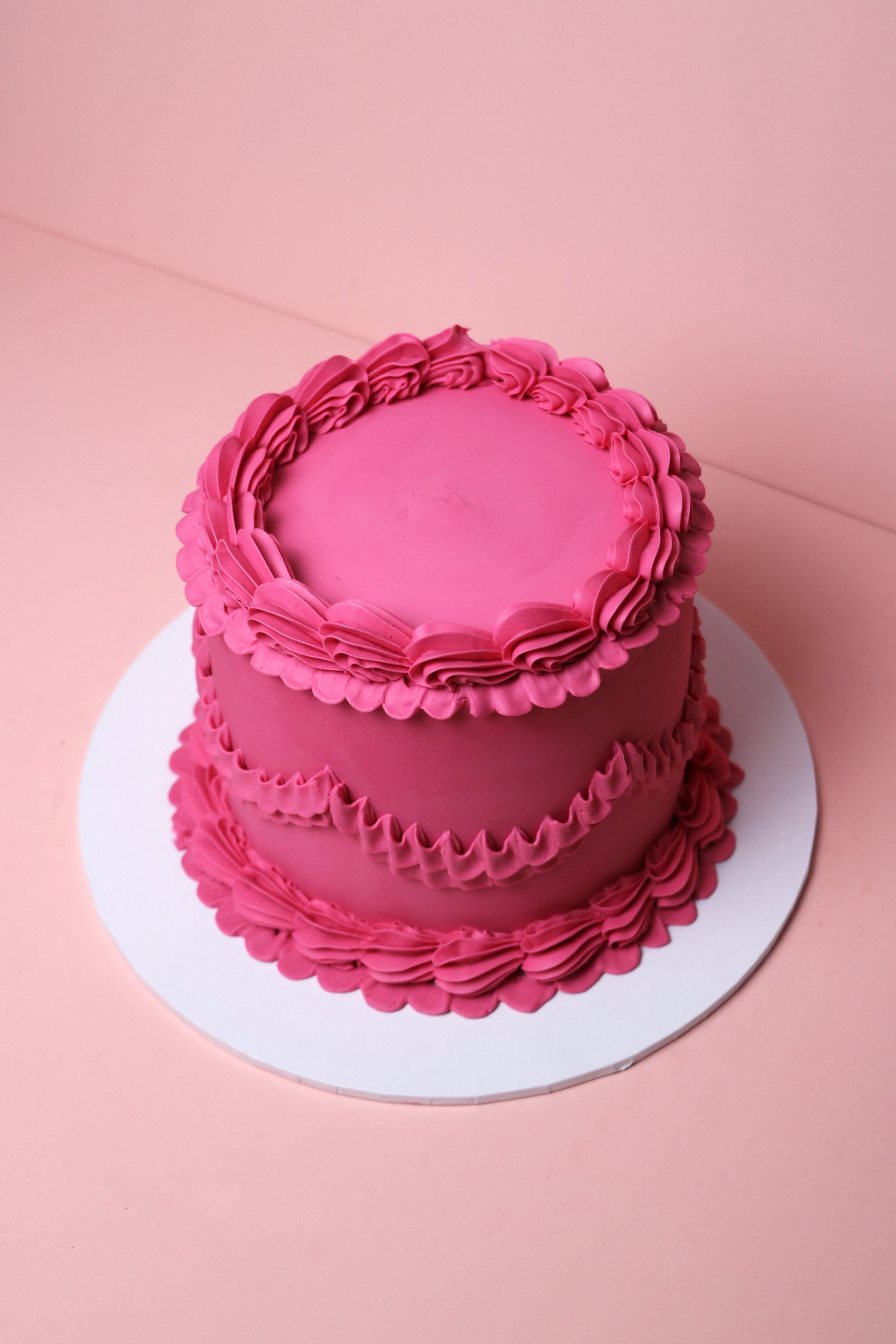 Bold pink colour block birthday cake with piped buttercream swirls, handmade in Uxbridge by CakeasionShop.