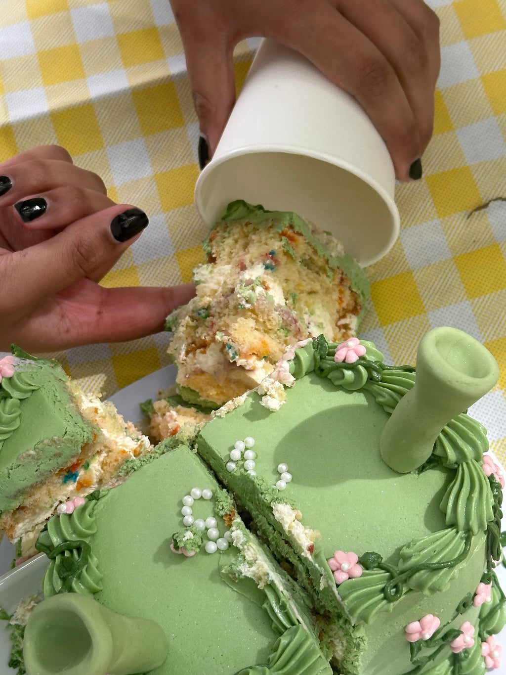 Slice of funfetti vanilla sponge from green floral Shrek cake being served at picnic at Cakeasion in Uxbridge.