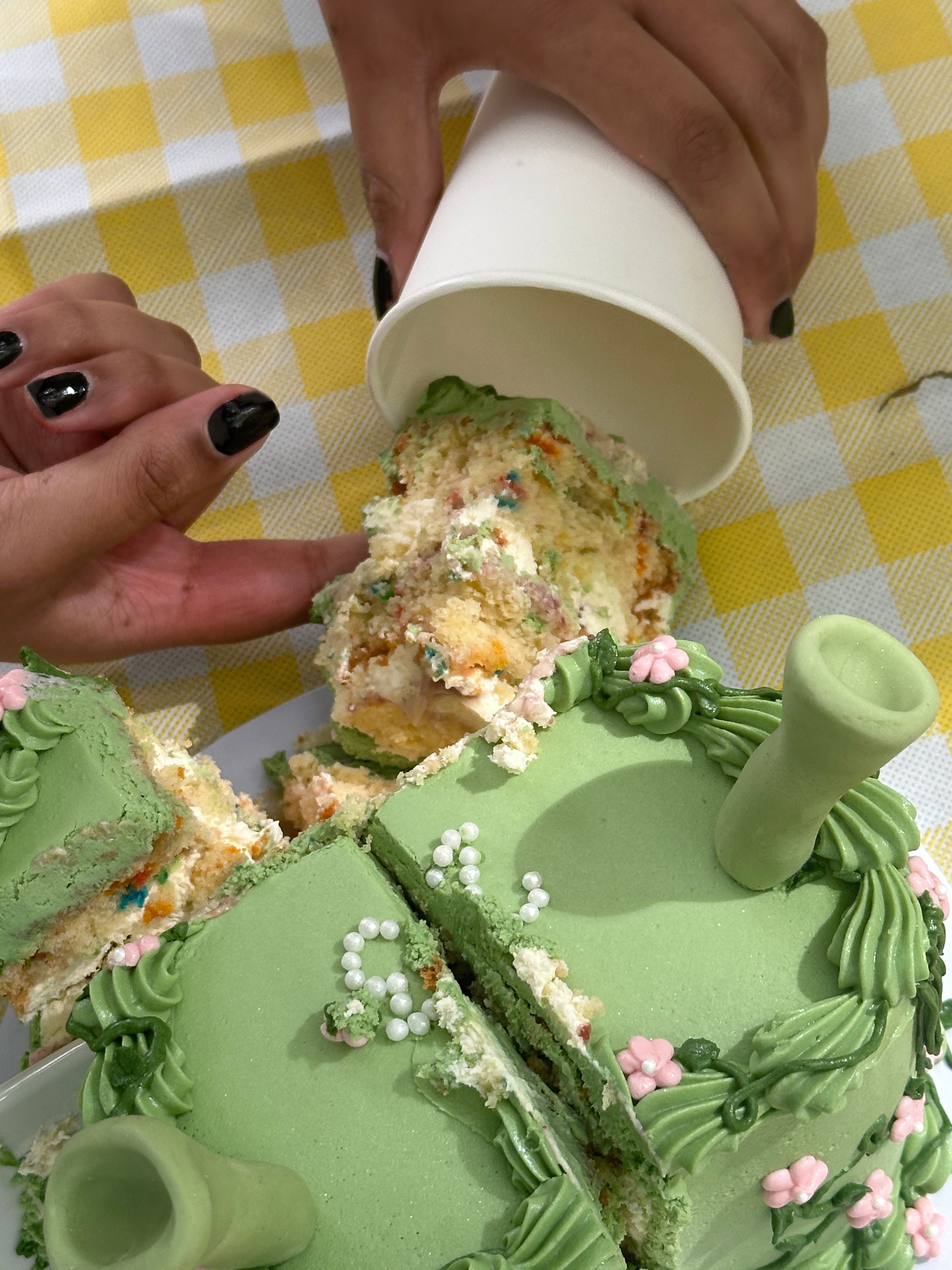 Slice of funfetti vanilla sponge from green floral Shrek cake being served at picnic at Cakeasion in Uxbridge.